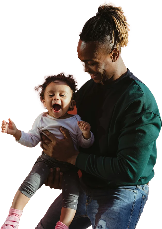 A smiling man holding a laughing toddler in his arms.