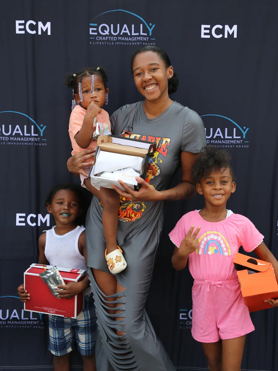 Kids posing for a photo with gifts in an ECM event